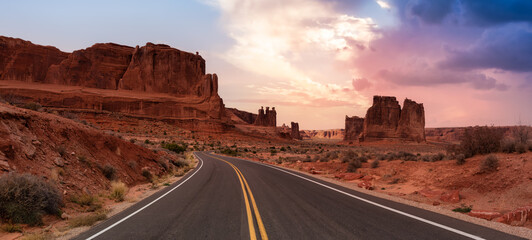 Vue panoramique sur le paysage d& 39 une route panoramique dans les canyons de roches rouges. Rendu Artistique De Ciel Coucher De Soleil Coloré Dramatique. Pris dans Arches National Park, situé près de Moab, Utah, États-Unis.