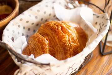 Freshly baked golden croissant in rustic basket