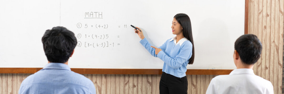 Educational concept a young smart female teacher explaining decision of hard math in a classroom before Covid-19 epidemic