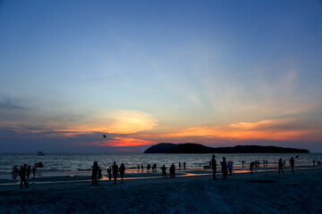 Langkawi, Malaysia, 6 March 2018: Silhouette of people enjoying the beach during sunset at Chenang Beach, Langkawi.