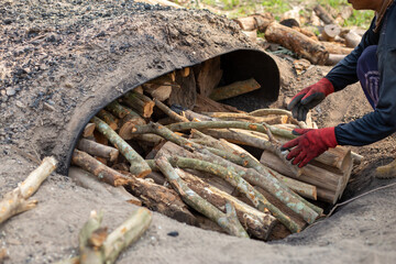 Obraz premium A pile of wood in the gardeners' turtles burning coals Lychee farmers in Thailand, after decorating the branches, burn the charcoal with water to generate additional income.