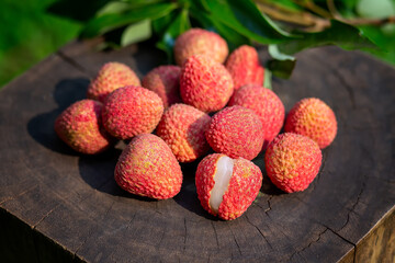 close-up piles of red lychees, tight white flesh with green leaves placed on the stump, looks appetizing, Thai lychee tongue in summer