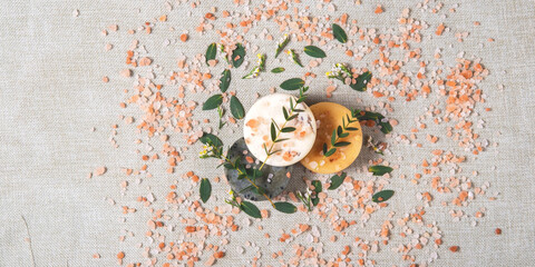 Three round natural handmade soaps and salt with the twigs of eucalyptus on the cotton background....