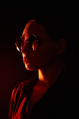 woman in sunglasses. Girl in red light