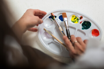 artist's paints and brushes, artist's hands