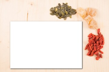 mock up of an empty white sheet on a wooden background with heaps of seeds as decoration Background mock up with a place for text copy space