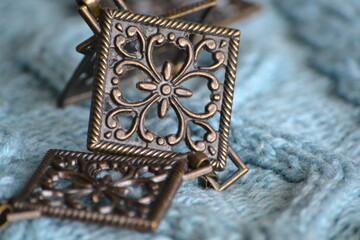 Accessories for female beauty. Metal female belt on knitted gray background. Selective focus and copy space. Craft concept. Vintage metal decorations.