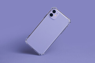 Phone case mockup isolated on purple background. iPhone 11 in clear silicone case falls down back...