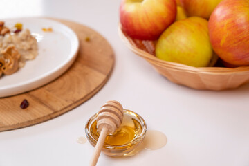 Liquid organic honey on a special spoon of honey in a bowl on a white background Close-up. Healthy food concept.