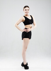 Fototapeta premium Full length of confident beautiful fitness woman standing over grey background