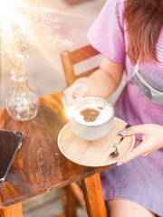 Woman drinking hot mocha with wood tray