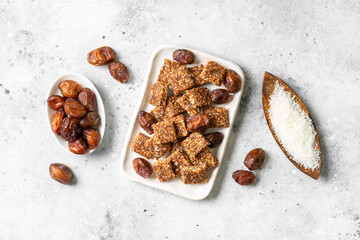 Coconut cookies with dates and carrots in a white bowl on a light background top view. The concept of a healthy snack no sugar