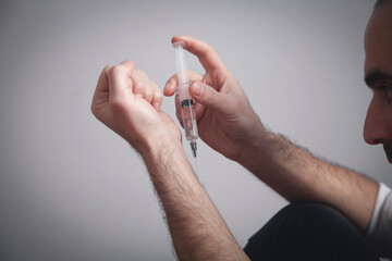 Drug addict man with a syringe. Addiction