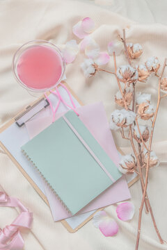 Notebook, Cotton Branch And Pink Drink On Beige Draped Fabric. Top View. Modern Aesthetic Flat Lay .