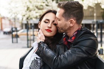 Beautiful couple in love wearing leather jackets during a date on a city street