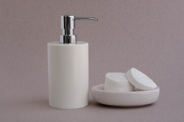 Fototapeta na wymiar Bath set white bottle with cotton pads and towel. Hygiene and health concept.