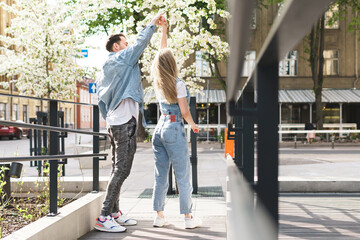 Young sensual and loving couple dancing during their date on a city street