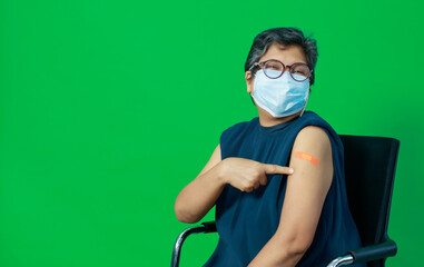 Asian middle age woman wearing protective hygiene mask showing bandage on arm looking to camera...
