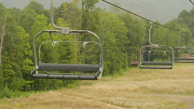 Empty chair lift working on green hills at ski resort. Rosa Khutor Sochi
