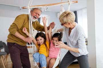 Grandchildren having fun, playing with grandparents at home