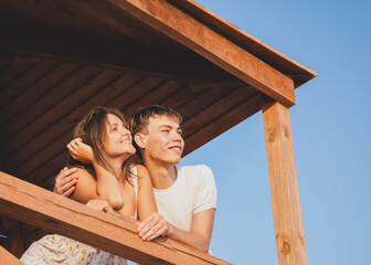 Obraz na płótnie Canvas Young couple looking away on blue sky background