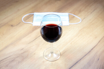 Medical mask near the a glass of wine. Alcoholic addict, Lost job, unemployment concept, economic crisis. Depression and alcoholism. Coronavirus (COVID-19)