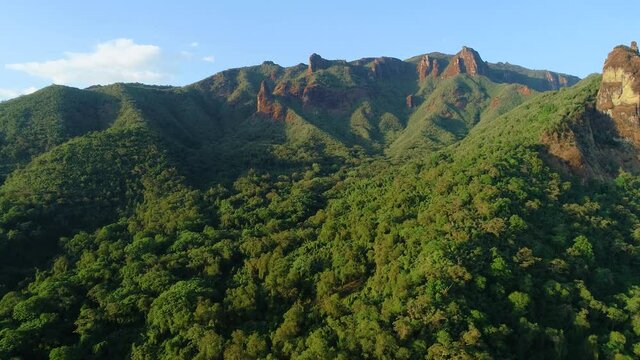 Flying over the cliffs and treetops of african rainforest in colorful evening light. Aerial video,  wild African nature in Harenna forest, Bale Mountains National Park in Ethiopia.