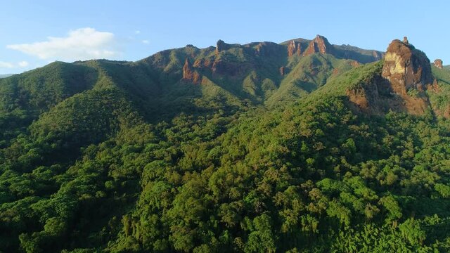 Flying over the cliffs and treetops of african rainforest in colorful evening light. Aerial video, remnants of wild African nature in Harenna forest, Bale Mountains National Park in Ethiopia.
