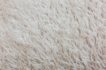 Beige cotton towel or carpet.fluffy texture background. Close up, macro photo. Soft focus image.
