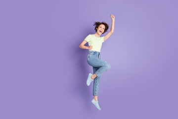 Fototapeta na wymiar Full length body size view of lovely overjoyed cheerful girl jumping having fun celebrating isolated over violet color background