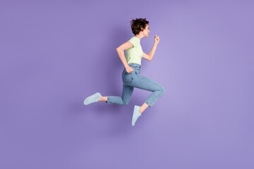 Fototapeta na wymiar Full length body size profile side view of lovely cheerful motivated girl jumping running fast isolated over violet color background