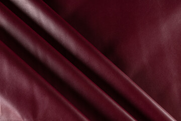 draped surface of eco-leather for sewing wine-colored garments, background