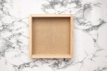 A empty wooden box isolated on marble background .