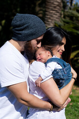 Parents hold the child in their arms. A little child with parents.