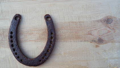 Old rusty horseshoe on a pine board. Natural wood background. Wood texture. Place for text.