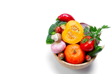 Set of fresh vegetables in a wooden bowl close-up. On a white isolated background. Healthy food concept. Copy space.