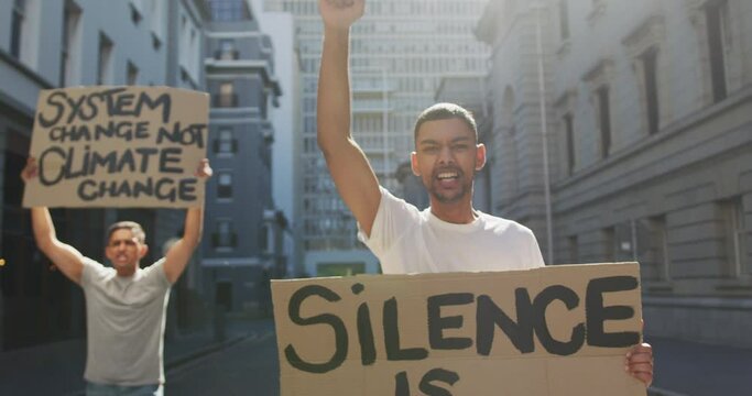 Two mixed race men on a protest march holding placards raising hands and shouting