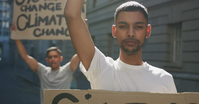 Two mixed race men on a protest march holding placards raising hands and shouting