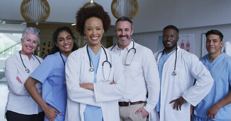 Portrait of diverse male and female doctors standing in hospital corridor smiling to camera - Powered by Adobe