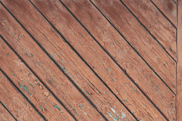 Fototapeta premium Old background with wooden boards with cracked, peeled red paint, vintage texture, rough textured surface close-up.