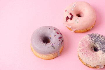 Tempting donuts dessert with iceing and sprinkles. Sweet sugar round doughnuts of different flavours. Top horizontal view copyspace. Healthy diet and junk food concept