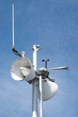 Views of a horn, antenna and navigation system in white metal in the mast of a ship with a blue sky...