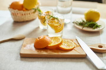Citrus and rosemary fresh lemonade in glass on a white table at home