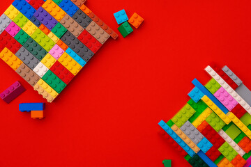 Plastic constructor details on red background close up