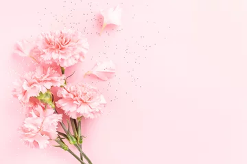 Pink carnations on pink background with confetti. © Olga Zarytska