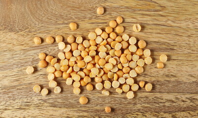 Yellow split peas pile on wooden board background and texture, top view