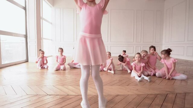 Girls dancers in ballet school learns to dance. Little Ballerinas in training in pink dancing suit. Children's ballet school. School of ballet.