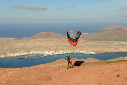 Man during departure with his parapent at Mirador del Rio on Lanzarote island in Spain