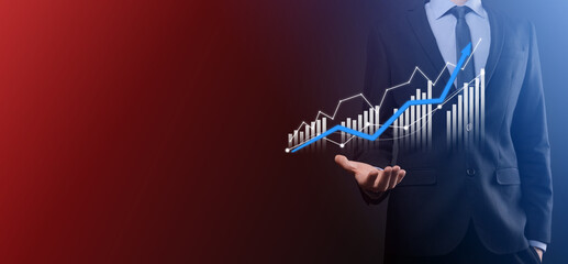 Obraz na płótnie Canvas Businessman hold drawing on screen growing graph, arrow of positive growth icon.pointing at creative business chart with upward arrows.Financial, business growth concept.