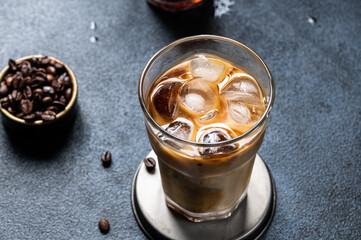 Iced coffee in a tall glass with cream poured over. Iced latte. Cold summer drink. Cold brew in glass. Cappuccino on Ice. Vietnamese Iced Coffee.